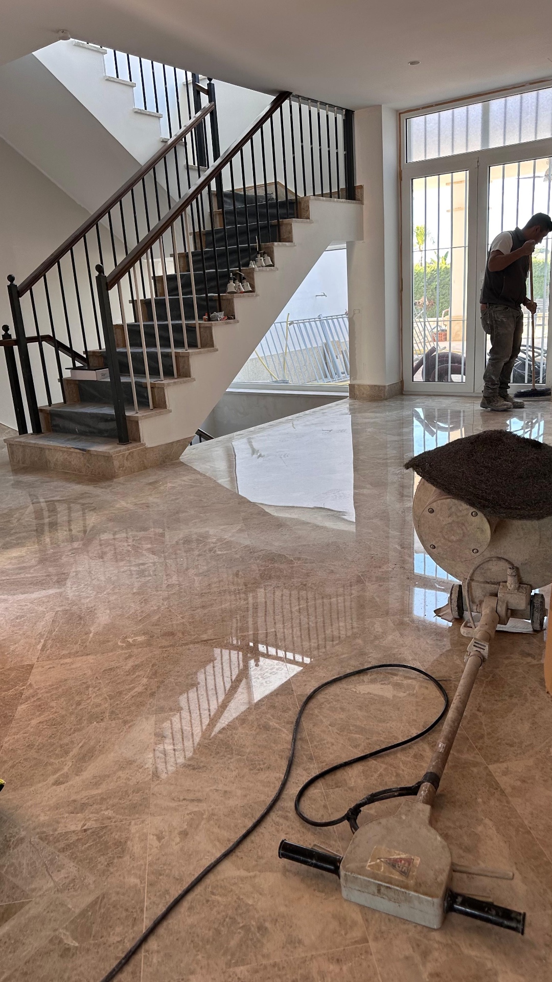 Professionnel travaillant avec une machine à brillanter près d’un escalier