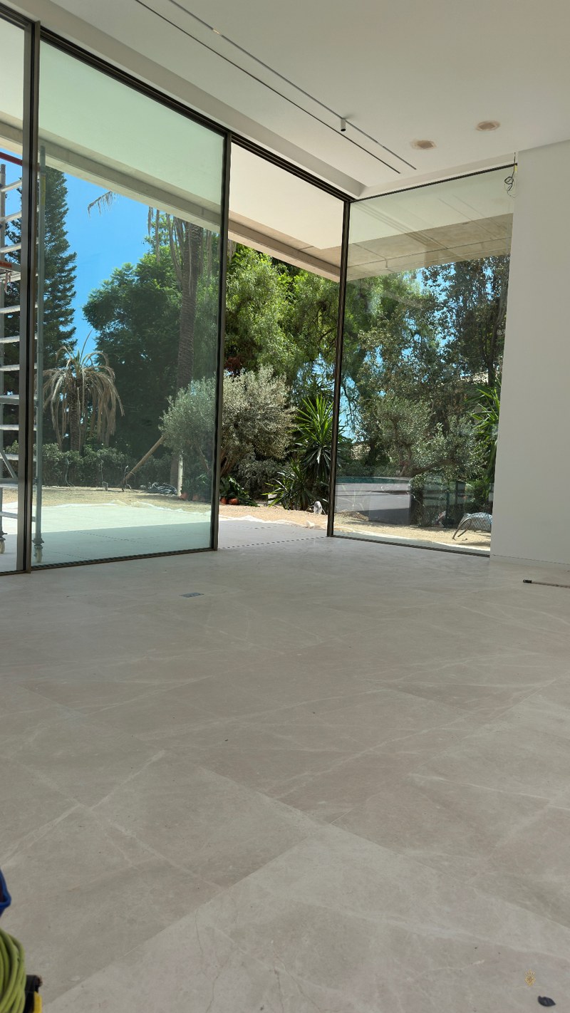 Grand salon avec sol en marbre mat et baies vitrées