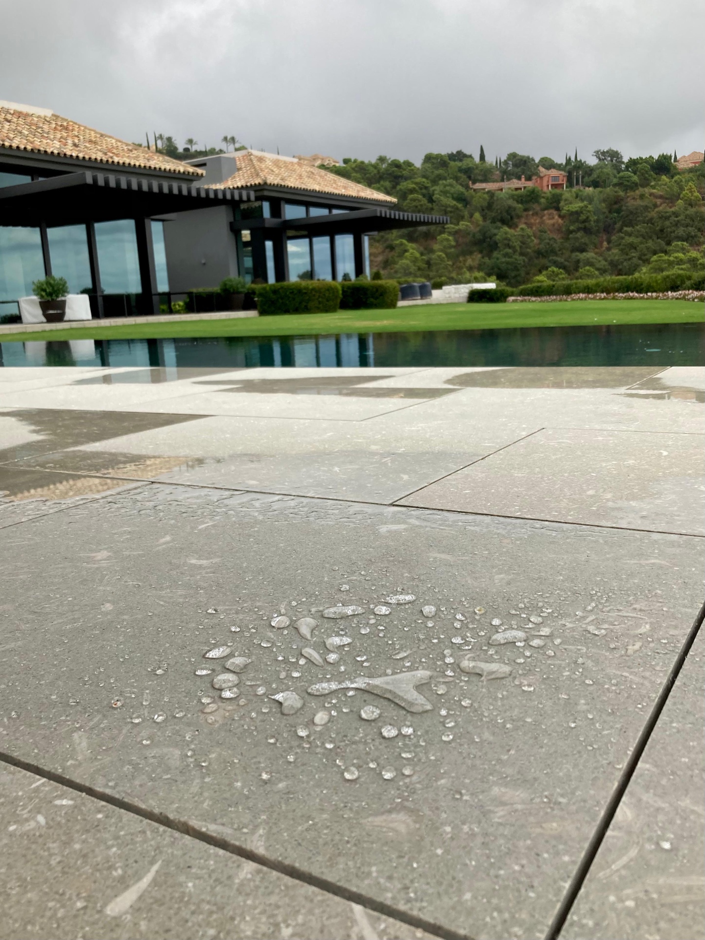 Pierre au bord d’une piscine avec gouttes d’eau après traitement